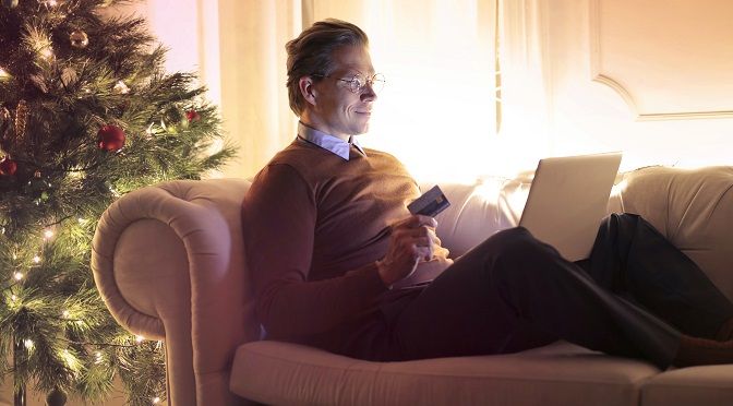 man-sitting-on-sofa-with-credit-card-and-laptop